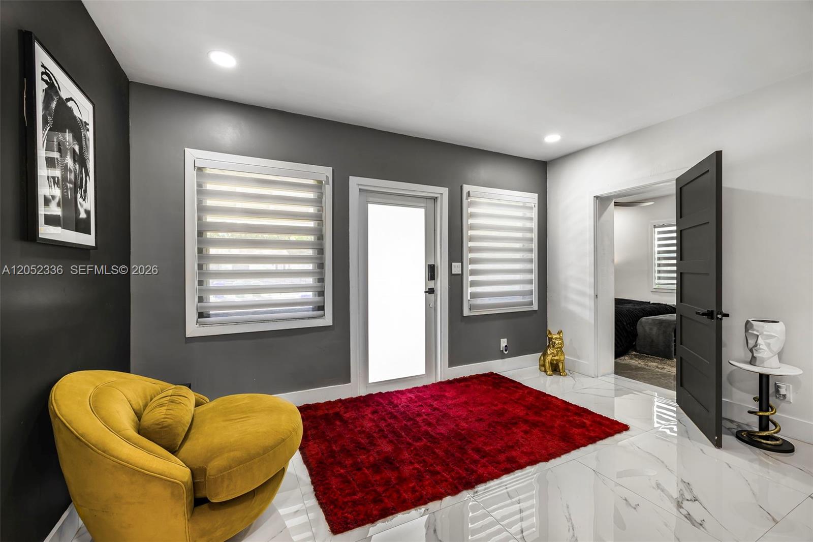 A room with white marble floors, a yellow chair, a red rug, and a doorway — 285 NW 45th St # 0, Miami FL 33127, MIAMI, FL
