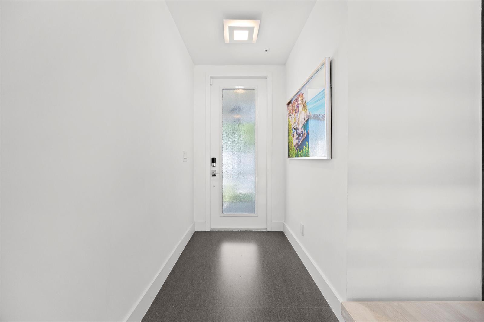 A bright entryway features a white front door with frosted glass, dark flooring, and artwork — 3055 Waterside Circle, Boynton Beach FL 33435, BOYNTON BEACH, FL
