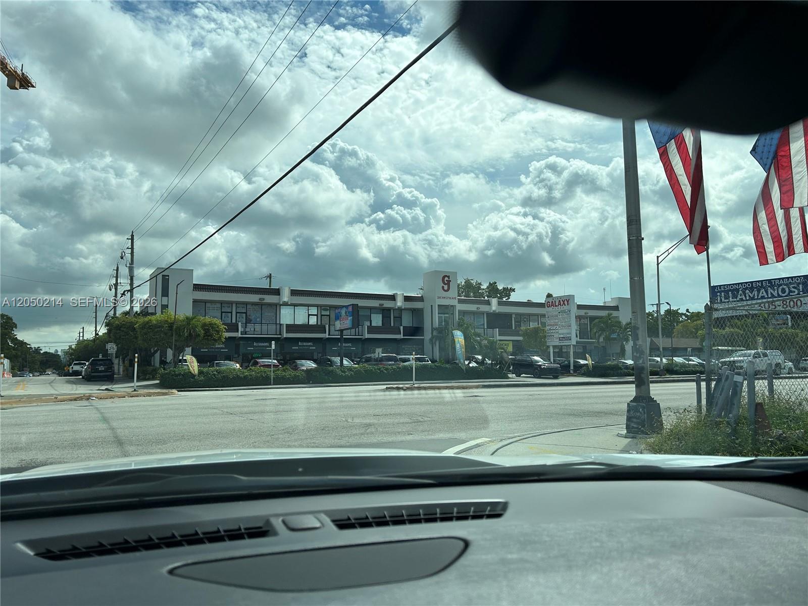 A view from inside a vehicle looking at a commercial strip mall across a street — 285 NW 27th Ave # 9, Miami FL 33125, MIAMI, FL