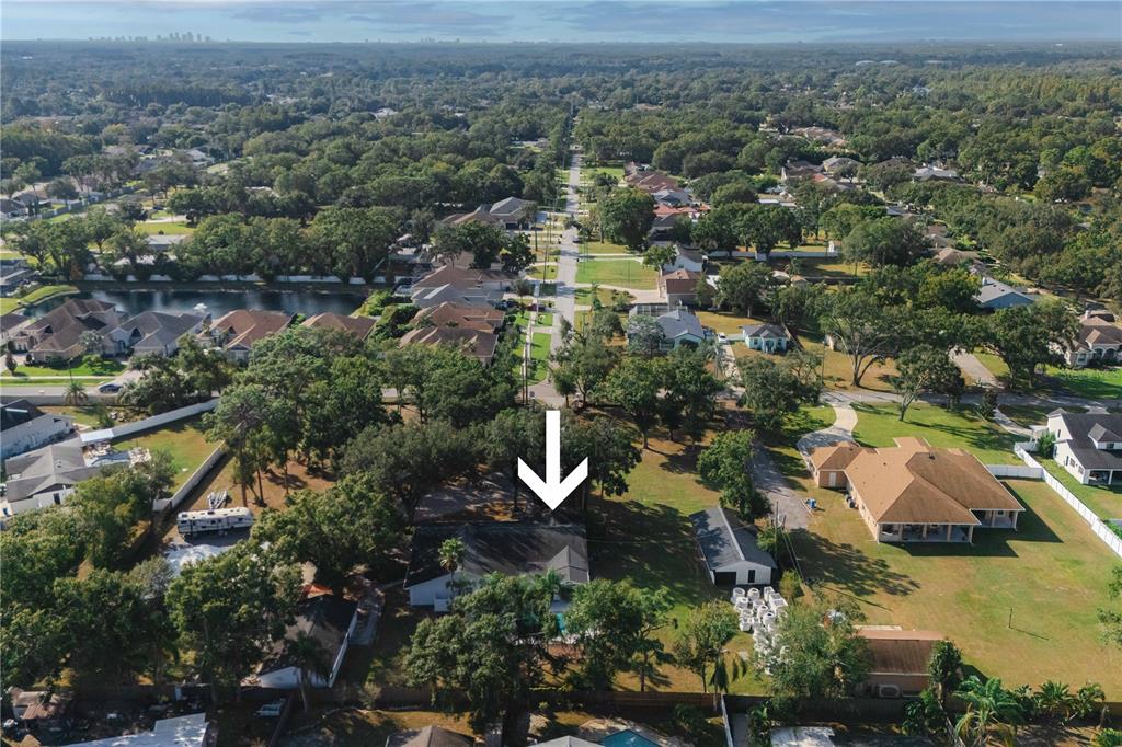 An aerial view shows a residential house with a white arrow pointing toward its roof — 15509 CASEY ROAD, TAMPA, FL