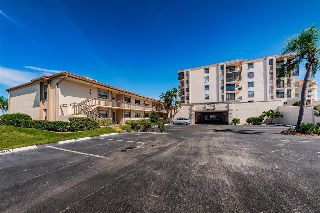 A multi-story apartment building with a parking lot and covered ground-level parking — 6145 SUN BOULEVARD UNIT 607, ST PETERSBURG, FL