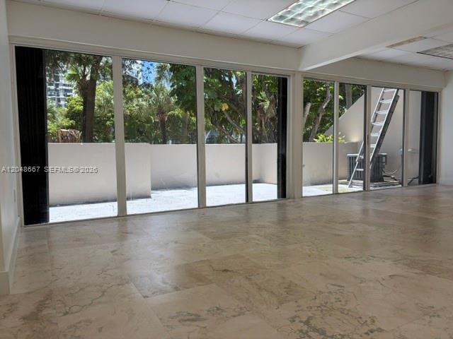 An interior room with large glass sliding doors, tile flooring, and a view of trees — 520 Brickell Key Dr # O208, Miami FL 33131, MIAMI, FL