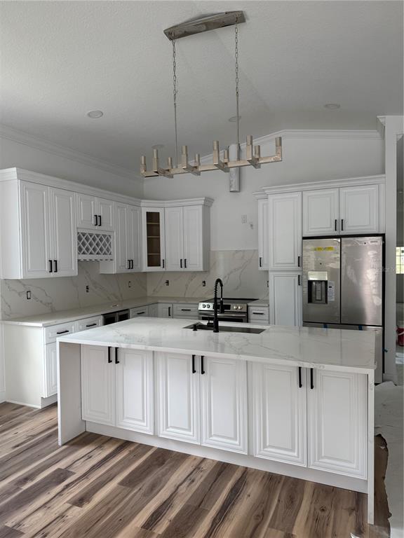 A kitchen with white cabinetry and a central island opens into a large living area — 611 ELM STREET, SAFETY HARBOR, FL