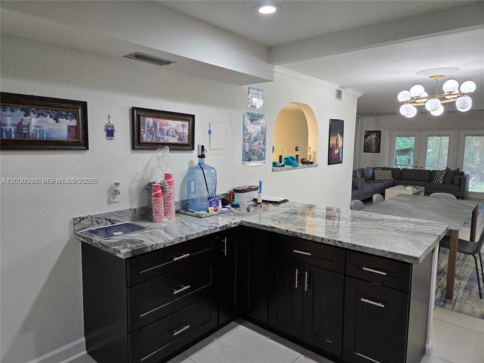 A kitchen features dark wood cabinets, granite countertops, and a water cooler — 295 Jacaranda Dr # 20, Plantation FL 33324, PLANTATION, FL