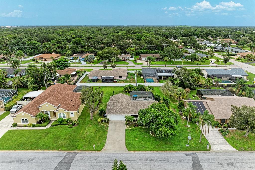An aerial view of a suburban neighborhood featuring several single-family homes with pools and lawns — 4723 PALM AIRE CIRCLE, SARASOTA, FL