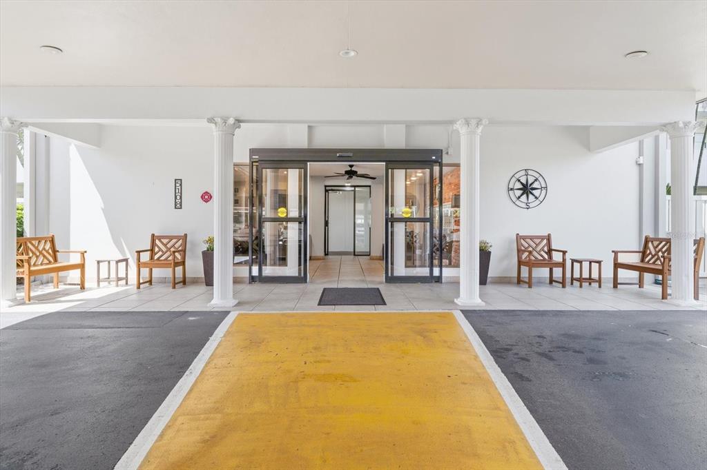 This is an exterior view of a building entrance with a covered portico and columns — 5108 BRITTANY DRIVE S UNIT 607, ST PETERSBURG, FL