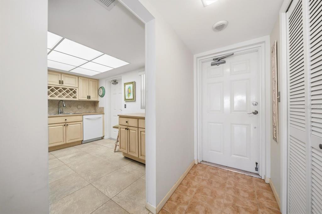 A view from an entryway into a kitchen with light wood cabinets and tile flooring — 5108 BRITTANY DRIVE S UNIT 607, ST PETERSBURG, FL