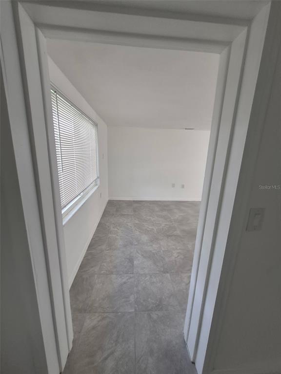 A view through a doorway into a room with gray tile flooring and white walls — 27 E LEMON STREET, BEVERLY HILLS, FL