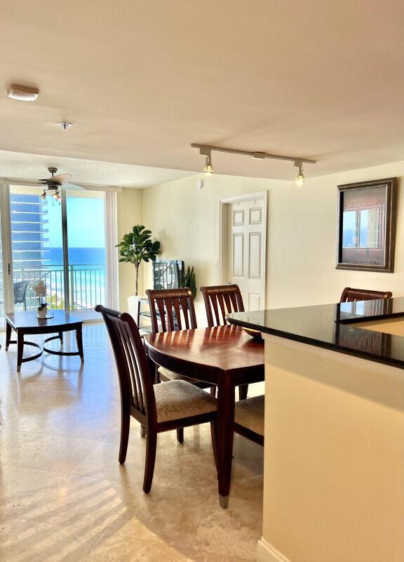 A dining area with a wooden table and chairs overlooks a balcony with ocean views — 2080 S Ocean Drive # 1608, Hallandale Beach FL 33009, HALLANDALE BEACH, FL