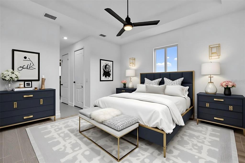 A modern bedroom features a navy upholstered bed, matching nightstands, and a gold-accented bench — 10071 KINGSVILLE DRIVE, PORT CHARLOTTE, FL