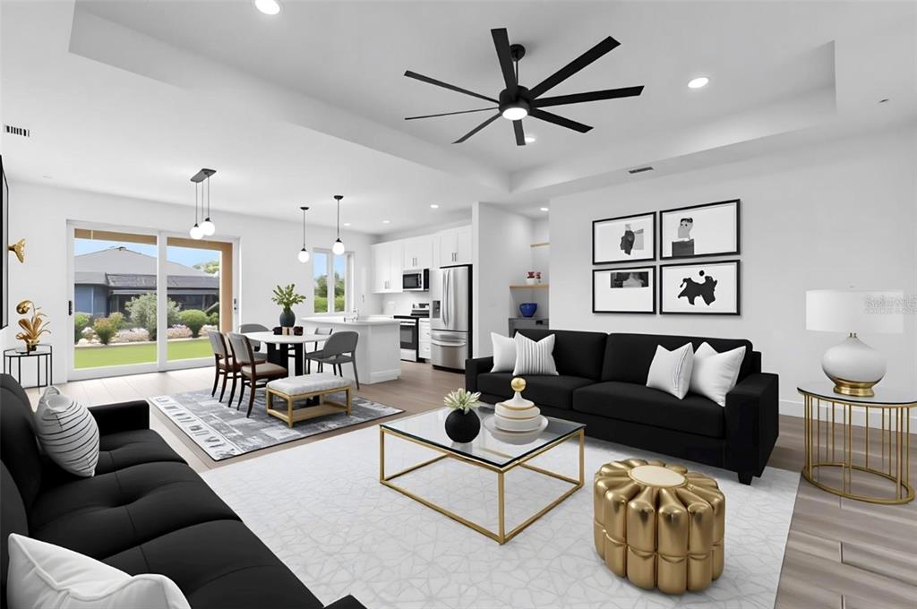 This open-concept living room and kitchen features black sofas, a gold coffee table, and tile flooring — 10071 KINGSVILLE DRIVE, PORT CHARLOTTE, FL