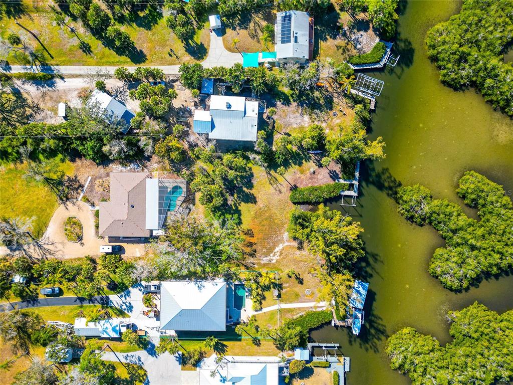 An aerial view shows several waterfront homes with pools and docks along a mangrove shoreline — 950 OXFORD DRIVE, ENGLEWOOD, FL