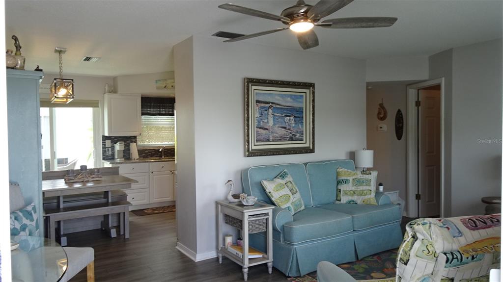 A living room with a light blue sofa and a dining area in the background — 7868 40TH AVENUE N UNIT 7868, ST PETERSBURG, FL