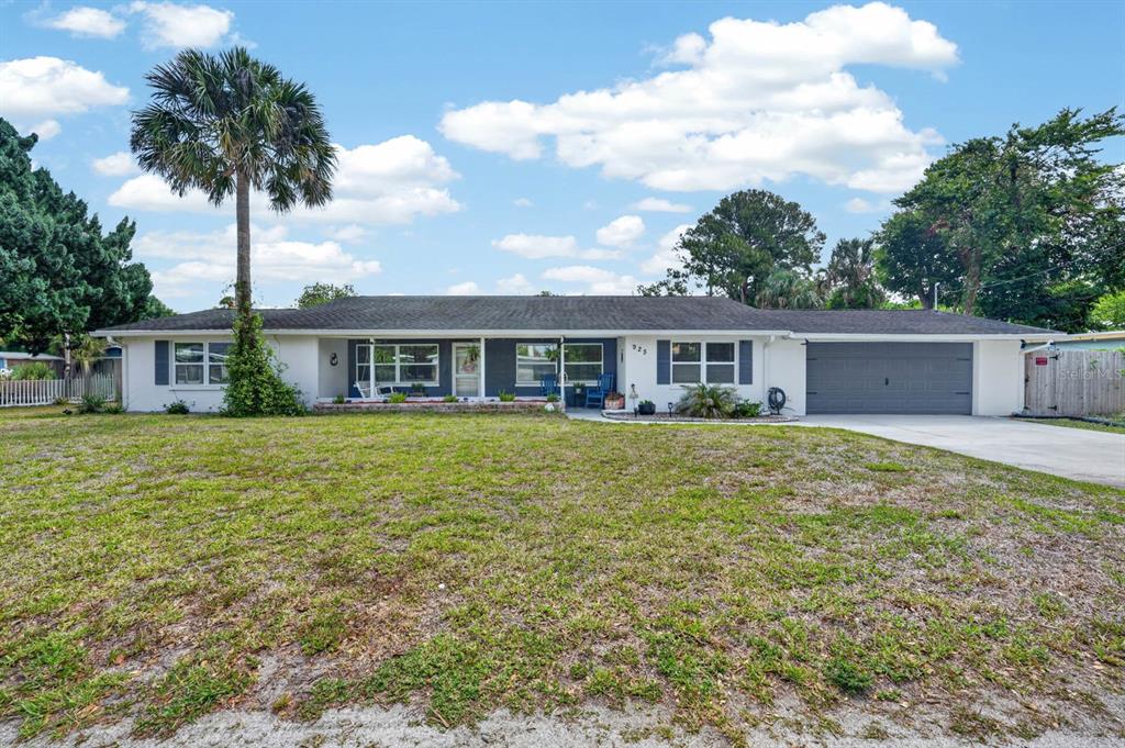 A single-story ranch-style house with a gray garage door and a large front lawn — 925 FLAGLER AVENUE, EDGEWATER, FL