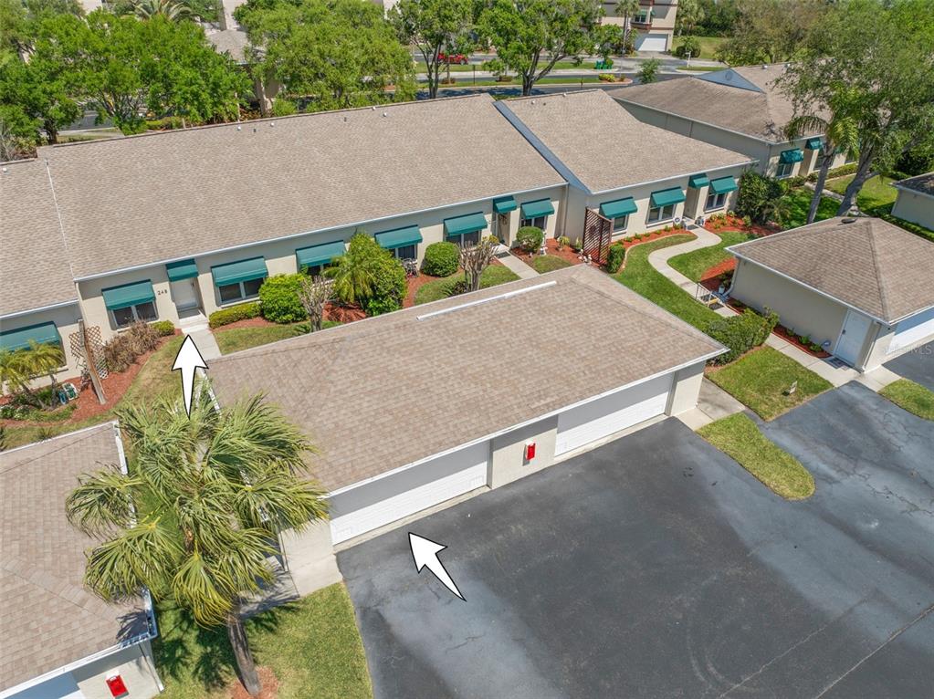 An aerial view shows a residential building with a garage and a front entrance walkway — 6600 100TH WAY N UNIT 24B, ST PETERSBURG, FL