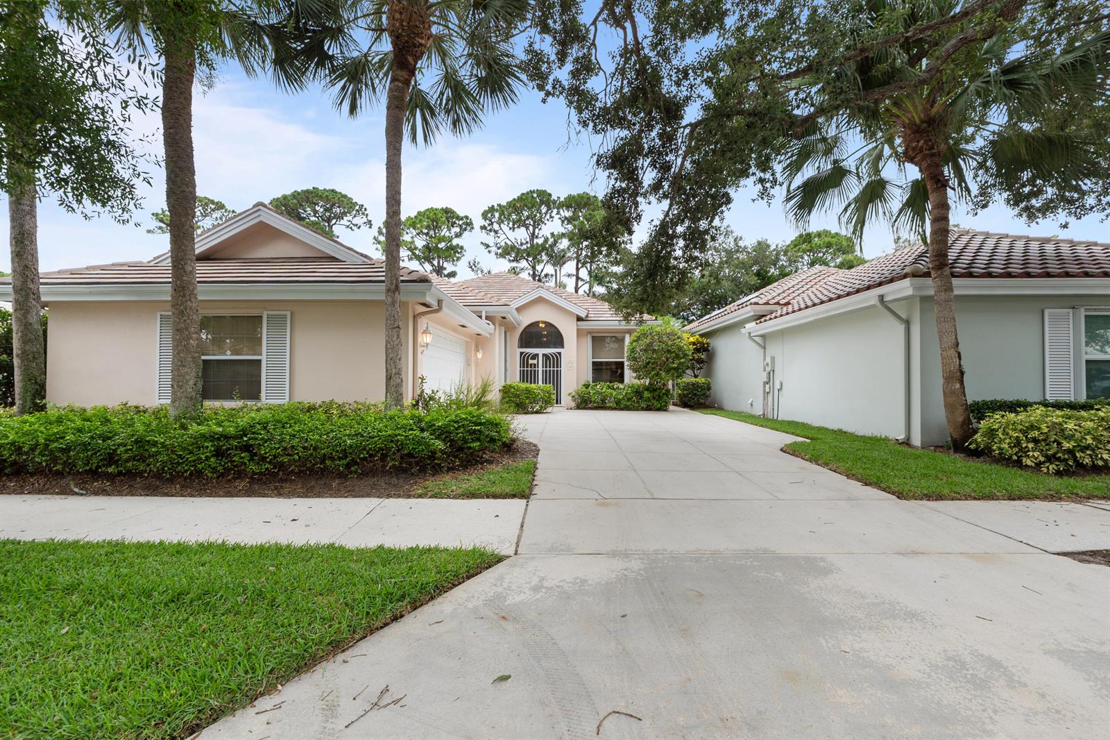 A single-story house with a concrete driveway, palm trees, and a tiled roof — 186 S Hampton Drive, Jupiter FL 33458, JUPITER, FL
