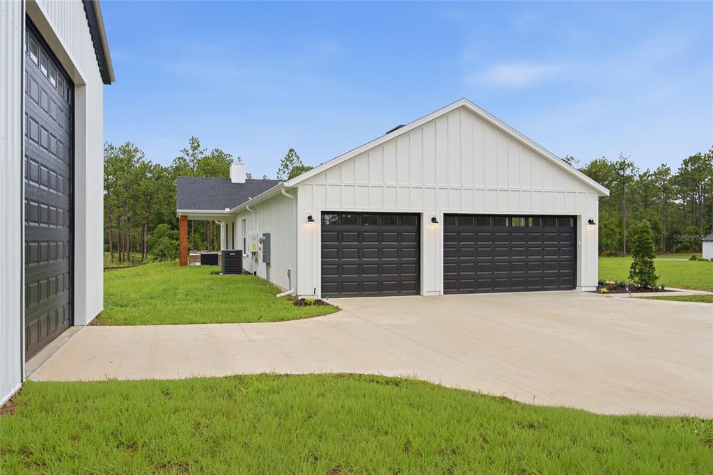 A covered porch features white board-and-batten siding, recessed lighting, and wooden support columns — 8730 NW 17TH CIRCLE, OCALA, FL