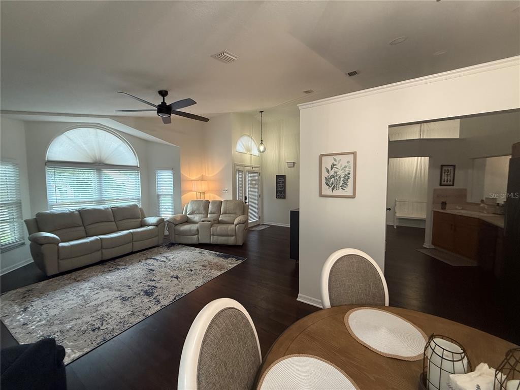 A living room features dark wood floors, a light-colored sofa set, and a ceiling fan — 6060 CONDOR DRIVE, LAKELAND, FL