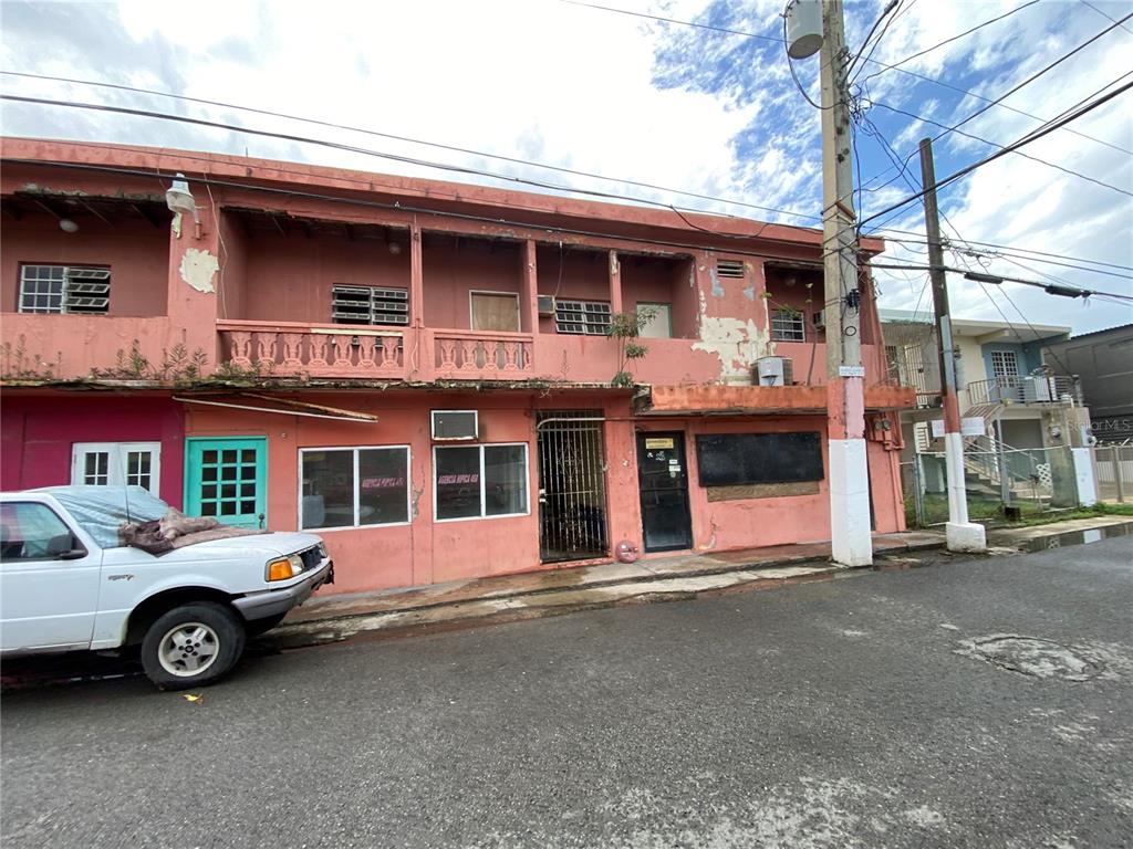 A two-story pink commercial building with a balcony and a white pickup truck parked outside — 47 Luis Munoz Rivera ST SR-101 POBLADO DE BOQUERON, CABO ROJO, PR