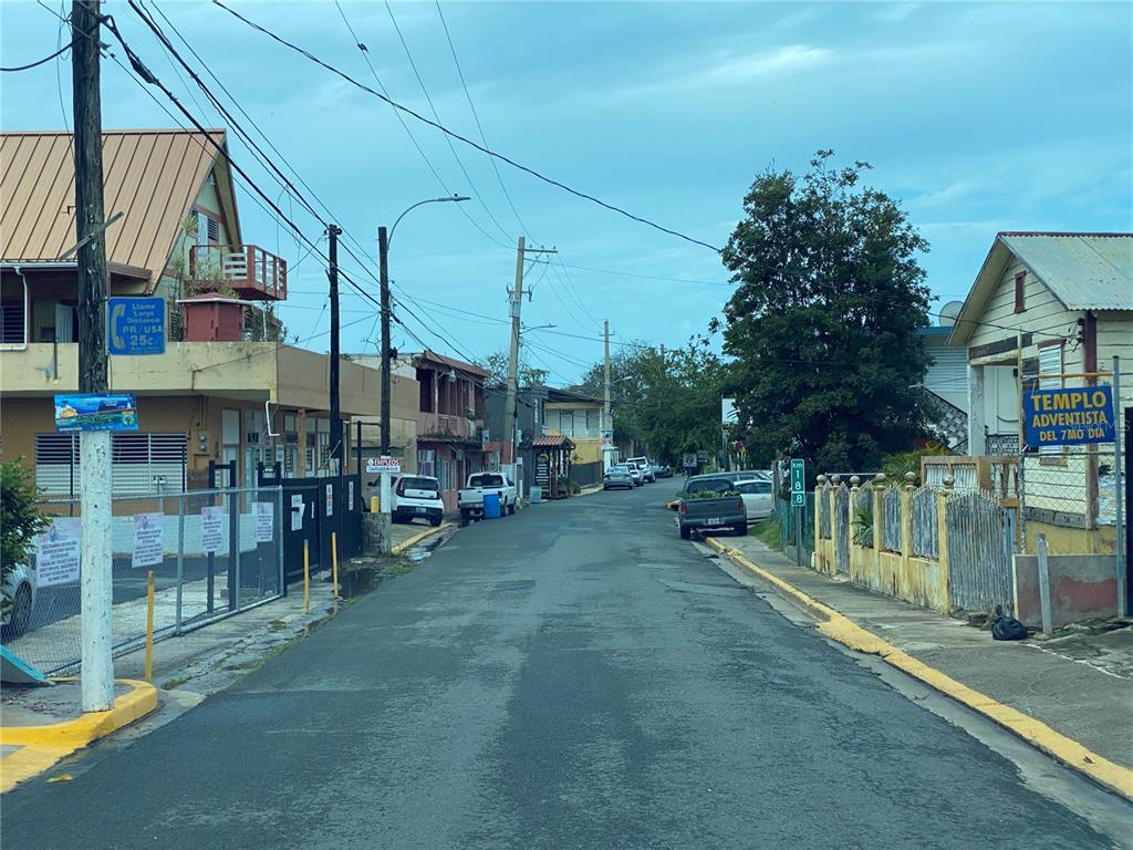 A street view shows a paved road lined with houses, utility poles, and a church sign — 47 Luis Munoz Rivera ST SR-101 POBLADO DE BOQUERON, CABO ROJO, PR