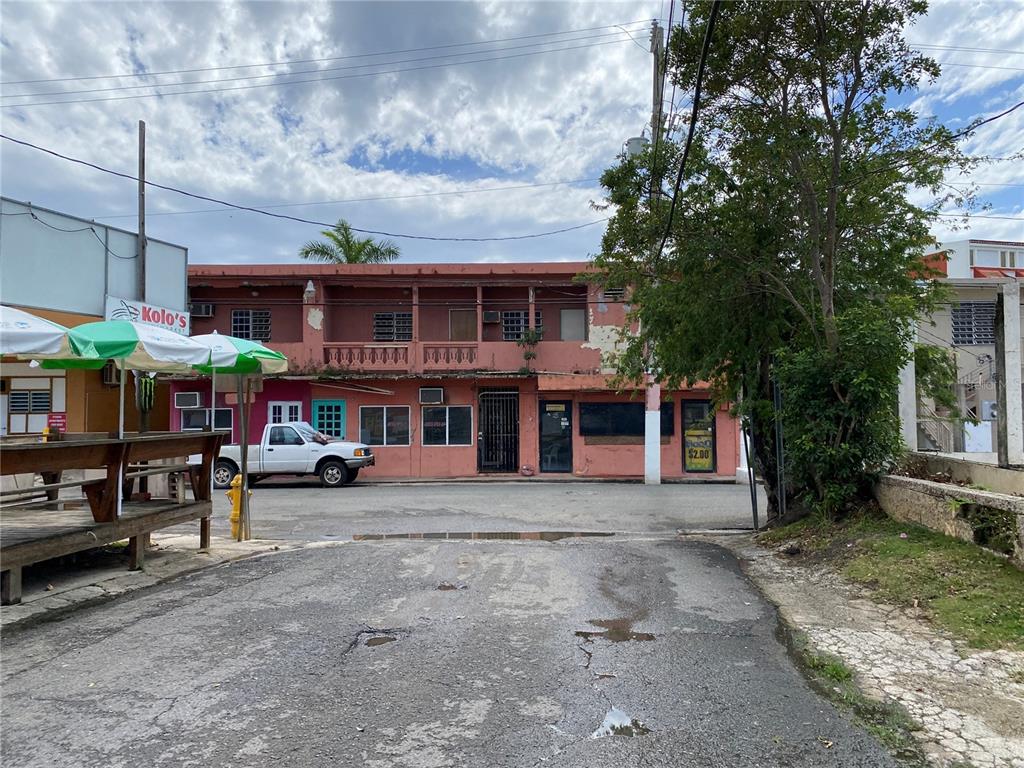 A two-story, pink-painted commercial building with a balcony and a white pickup truck parked outside — 47 Luis Munoz Rivera ST SR-101 POBLADO DE BOQUERON, CABO ROJO, PR