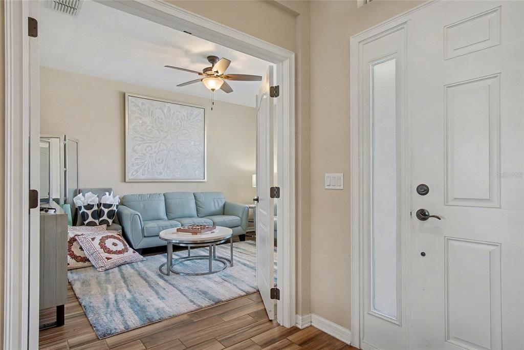 A view from an entryway into a living room with a light blue sofa — 1244 GATEWOOD AVENUE, MINNEOLA, FL