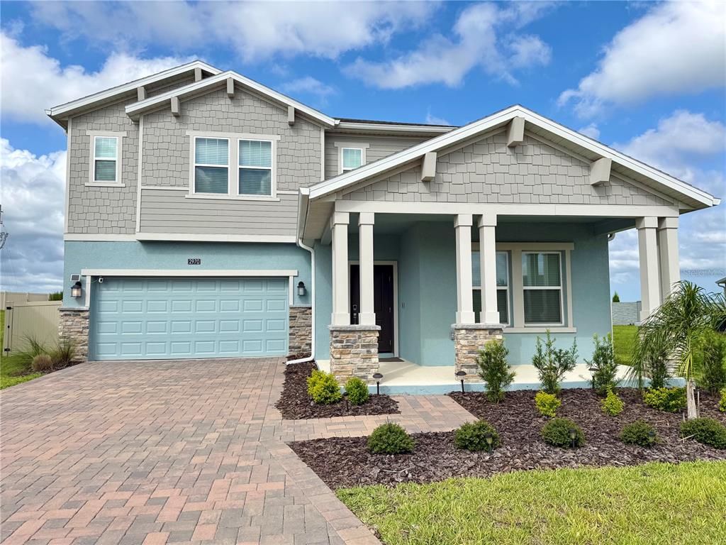 A two-story house with a blue stucco exterior, stone accents, and a covered front porch — 2970 ARMSTRONG AVENUE, CLERMONT, FL