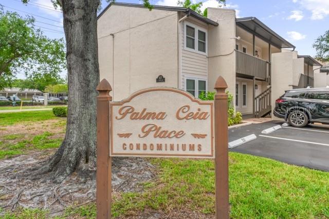 A sign for Palma Ceia Place Condominiums stands in front of a two-story apartment building — 527 S LINCOLN AVENUE UNIT A208, TAMPA, FL