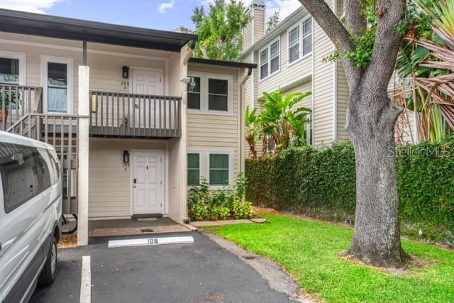 A two-story tan townhouse exterior features a ground-level entrance, a second-floor balcony, and parking — 527 S LINCOLN AVENUE UNIT A208, TAMPA, FL