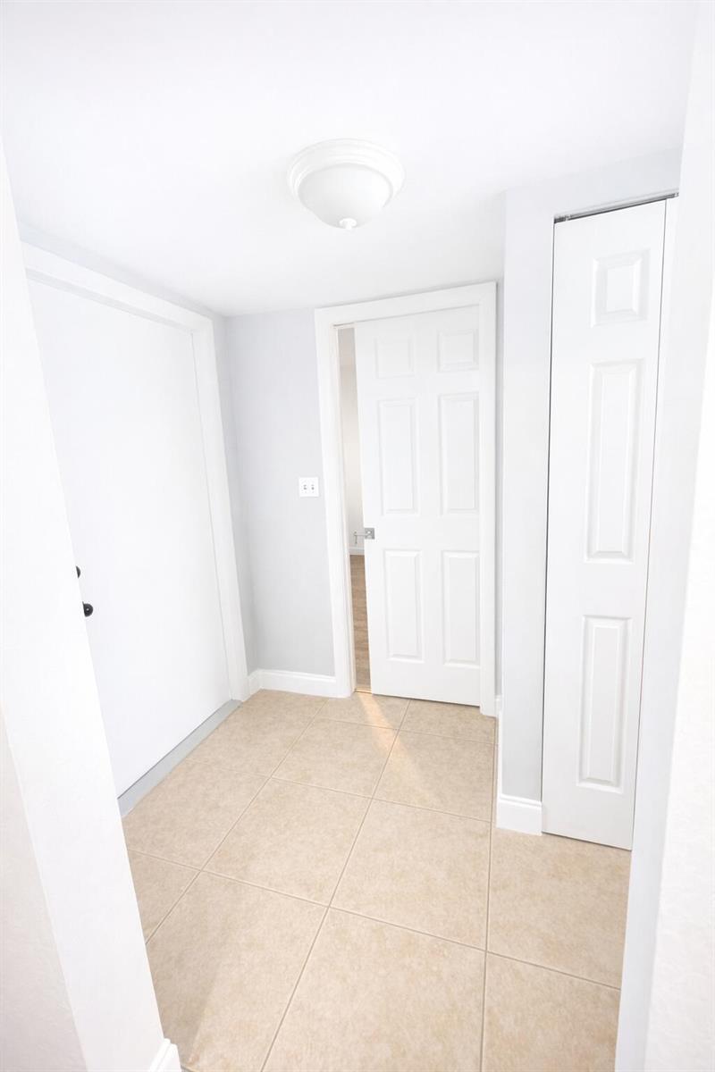 A small entryway with light-colored walls, tile flooring, a ceiling light, and white doors — 4052 N Pine Island Road # 1c, Sunrise FL 33351, SUNRISE, FL