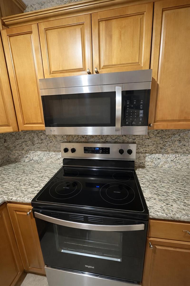 A kitchen featuring stainless steel appliances, wood cabinets, and granite countertops — 4052 N Pine Island Road # 1c, Sunrise FL 33351, SUNRISE, FL