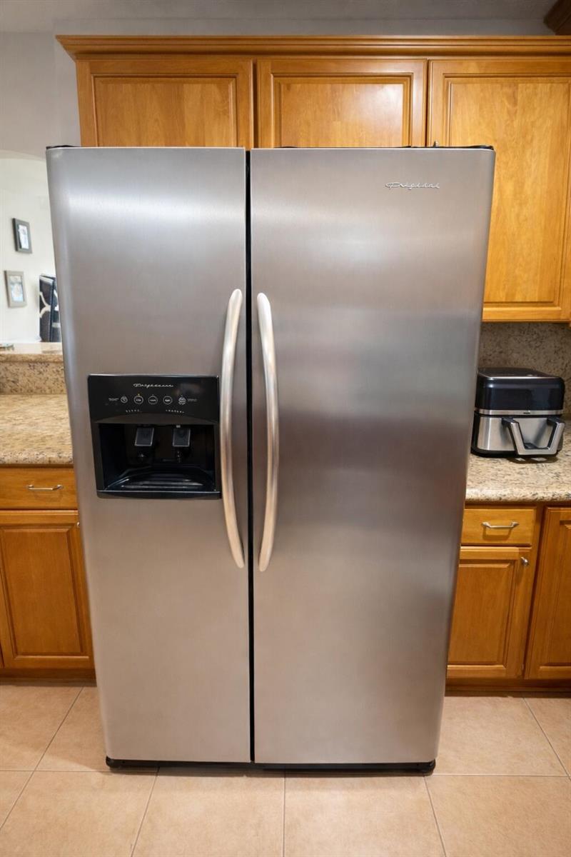 A stainless steel side-by-side refrigerator stands in a kitchen with wood cabinets and countertops — 4052 N Pine Island Road # 1c, Sunrise FL 33351, SUNRISE, FL