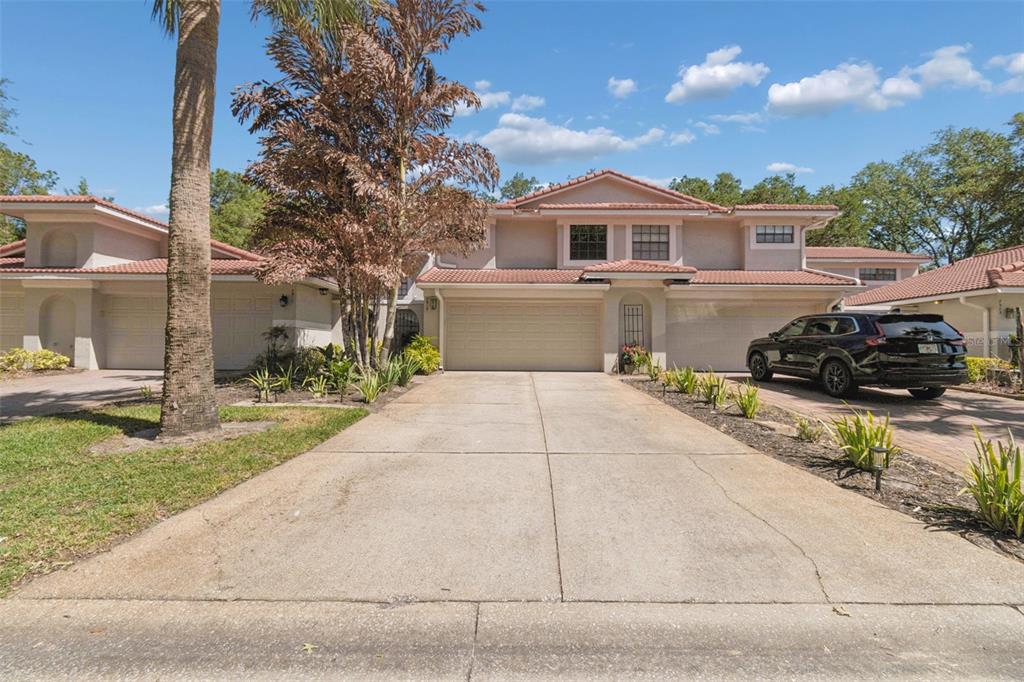 A two-story house with a tile roof, a concrete driveway, and a black SUV parked outside — 7913 BAYSIDE VIEW DRIVE, ORLANDO, FL