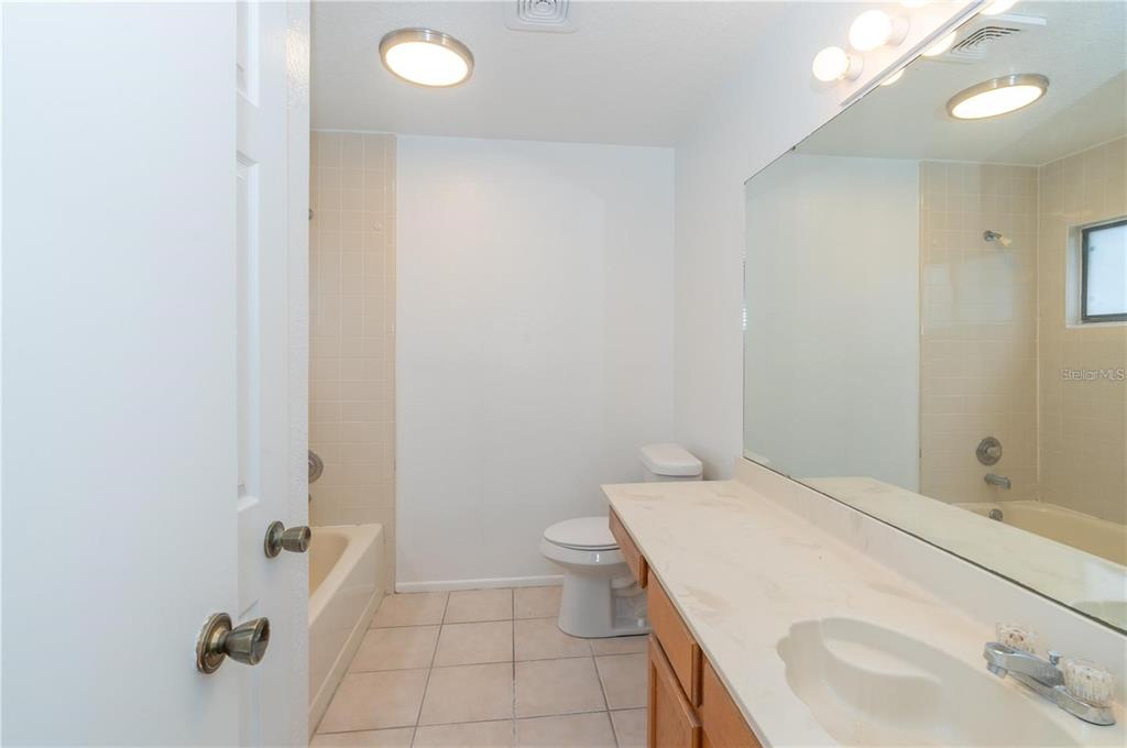 A bathroom features a vanity with a mirror, a toilet, and a tiled shower-tub combination — 660 HOLBROOK CIRCLE, LAKE MARY, FL