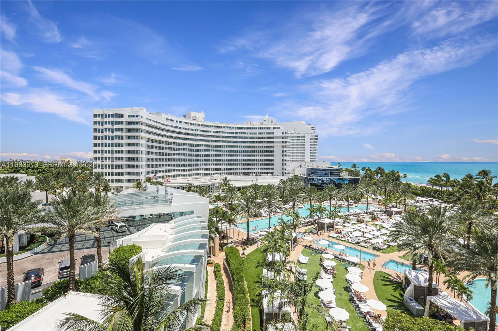 An aerial view shows a large curved hotel building overlooking a pool deck and ocean — 4391 Collins Ave # 605, Miami Beach FL 33140, MIAMI BEACH, FL