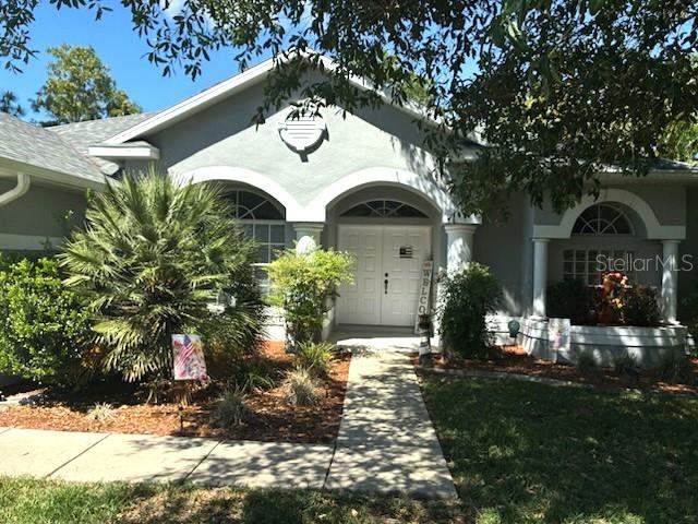 A gray single-story house with a white double-door entrance and a concrete walkway — 66 LONE PINE STREET, HOMOSASSA, FL