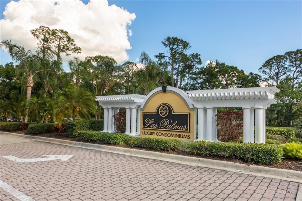 A multi-story residential building with a garage, screened balcony, and a large tree in front — 5655 BENTGRASS DRIVE UNIT 9-111, SARASOTA, FL