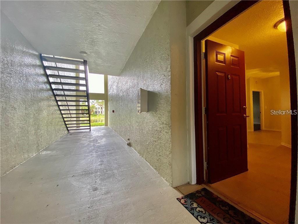 A yellow building with a central cupola and arched entryway sits behind a brick driveway — 5655 BENTGRASS DRIVE UNIT 9-111, SARASOTA, FL