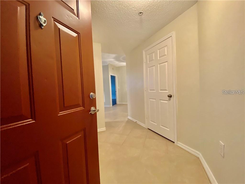 A brown front door labeled 111 sits next to an outdoor staircase on a concrete walkway — 5655 BENTGRASS DRIVE UNIT 9-111, SARASOTA, FL