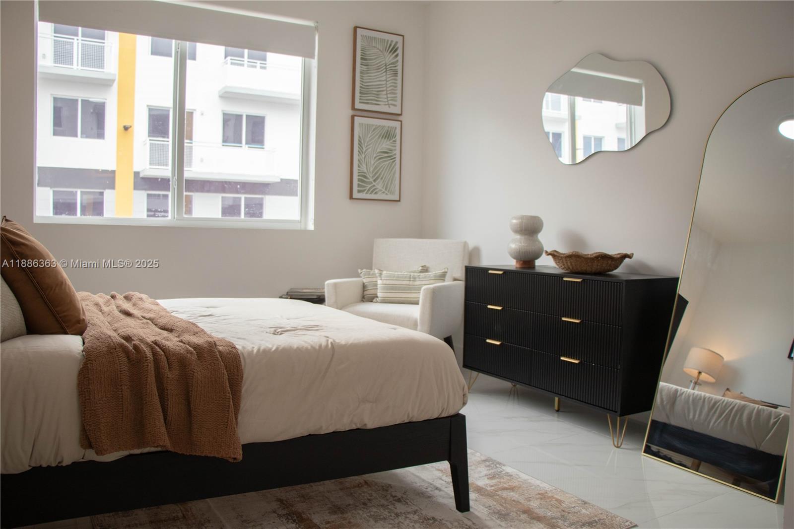 A bedroom features a bed, a black dresser, an armchair, and a full-length floor mirror — 1455 W 29th St # 113, Hialeah FL 33012, HIALEAH, FL