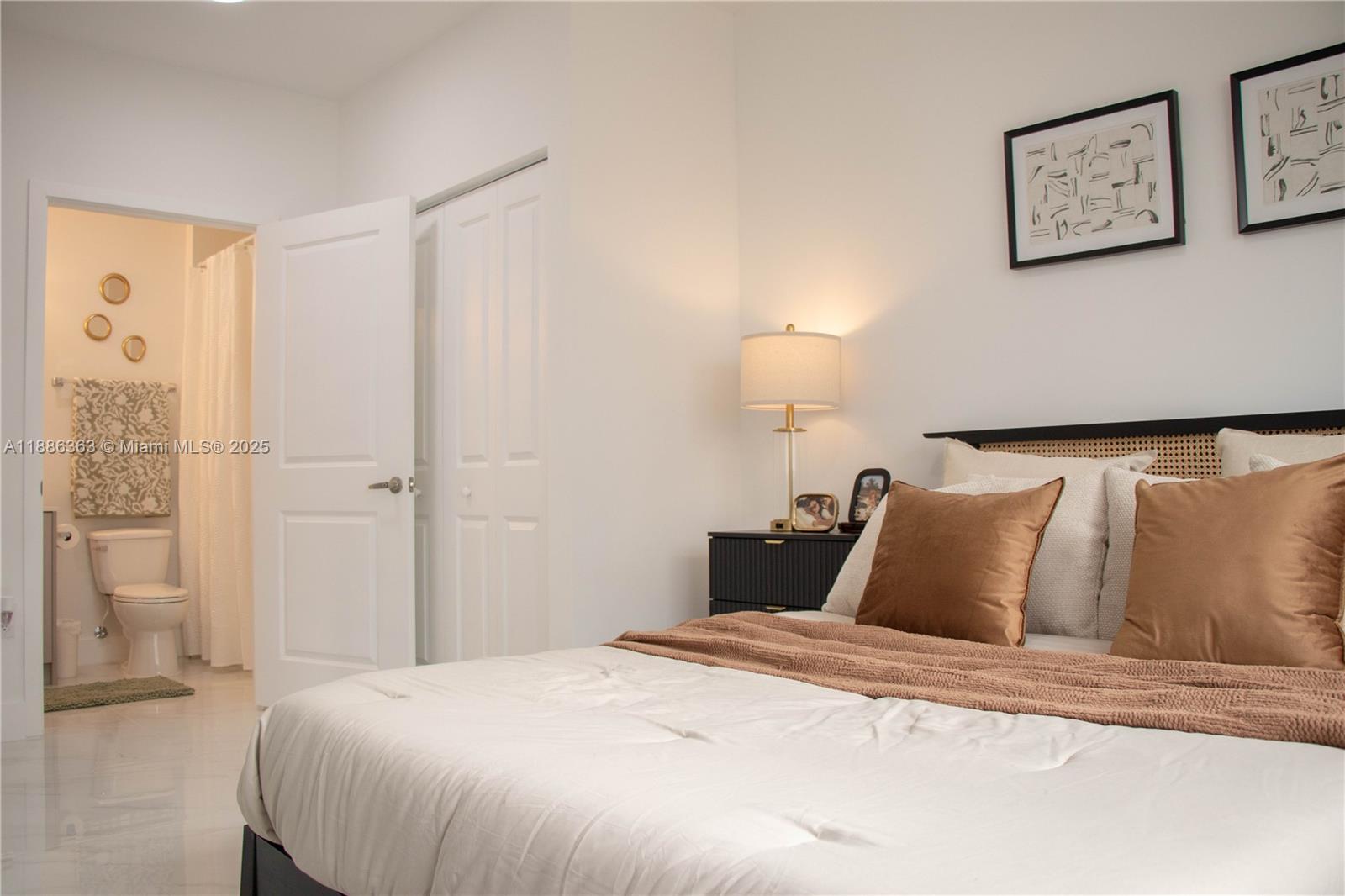 A bedroom with a white bed, a nightstand, and an attached bathroom with a toilet — 1455 W 29th St # 113, Hialeah FL 33012, HIALEAH, FL