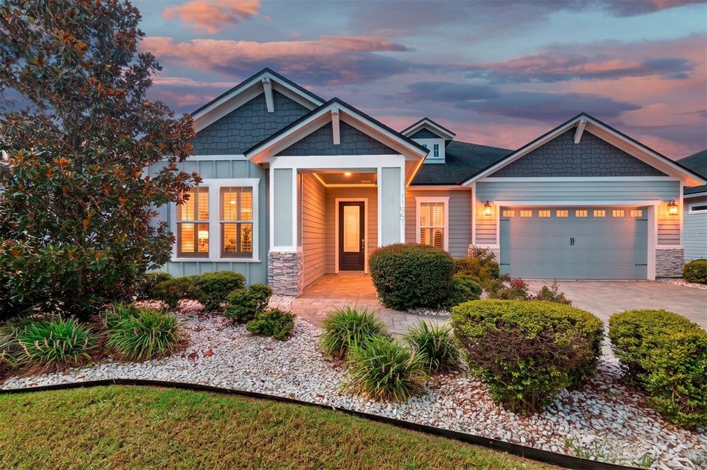 A single-story house with blue siding, a stone-accented entryway, and a two-car garage — 11951 SW 32ND LANE, GAINESVILLE, FL