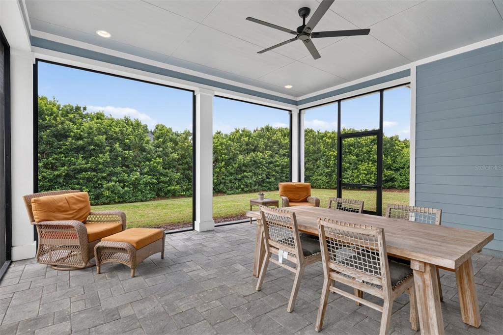 A screened-in patio features a dining set, lounge chair with ottoman, and paver flooring — 11951 SW 32ND LANE, GAINESVILLE, FL