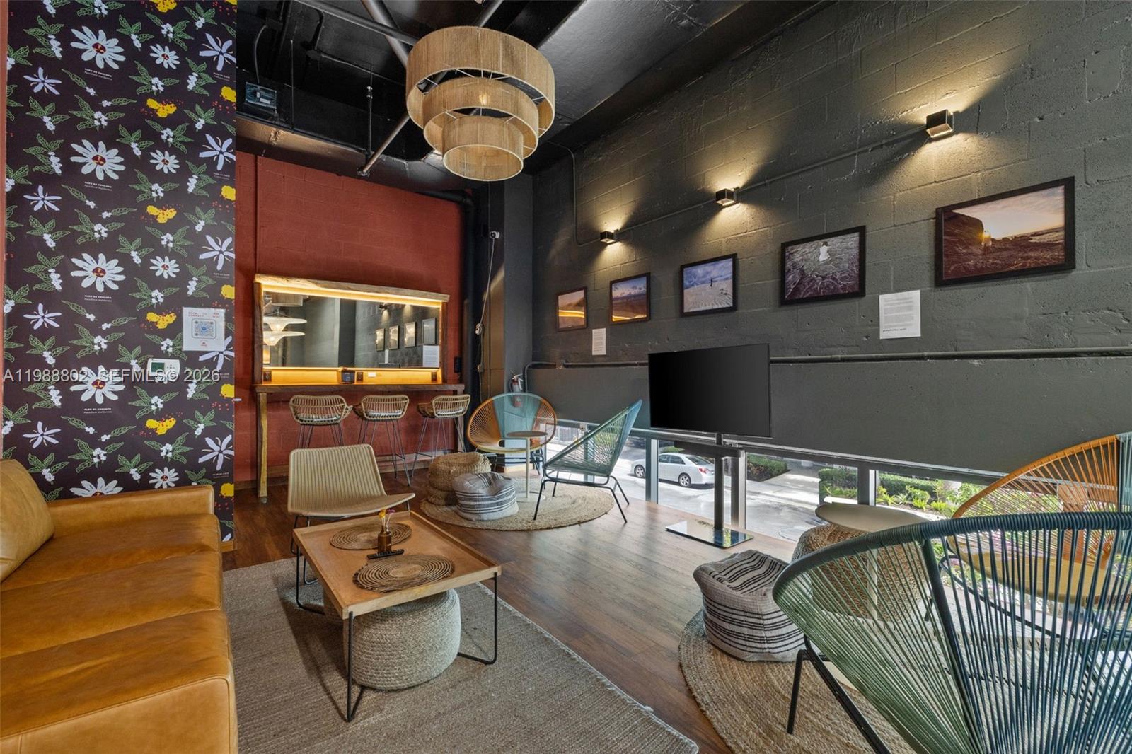 A modern lounge area features a leather sofa, patterned wallpaper, and several contemporary chairs — 239 SW 9th St # 101, Miami FL 33130, MIAMI, FL