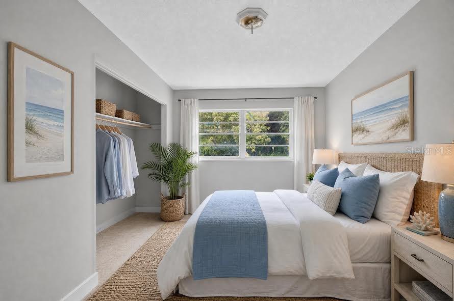 A bedroom features a bed with blue accents, an open closet, and coastal-themed wall art — 1700 COWAN CIRCLE, TITUSVILLE, FL