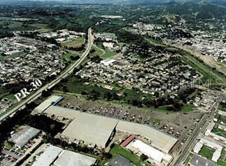 An aerial view shows a commercial building with a large parking lot near a highway — PR 3 KM 82.5, HUMACAO, PR
