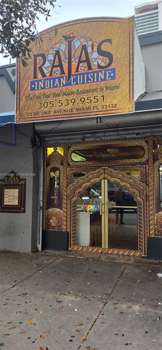 The exterior of a restaurant features a decorative arched entrance and a large signage banner — 33 NE 2nd Ave, Miami FL 33131, MIAMI, FL