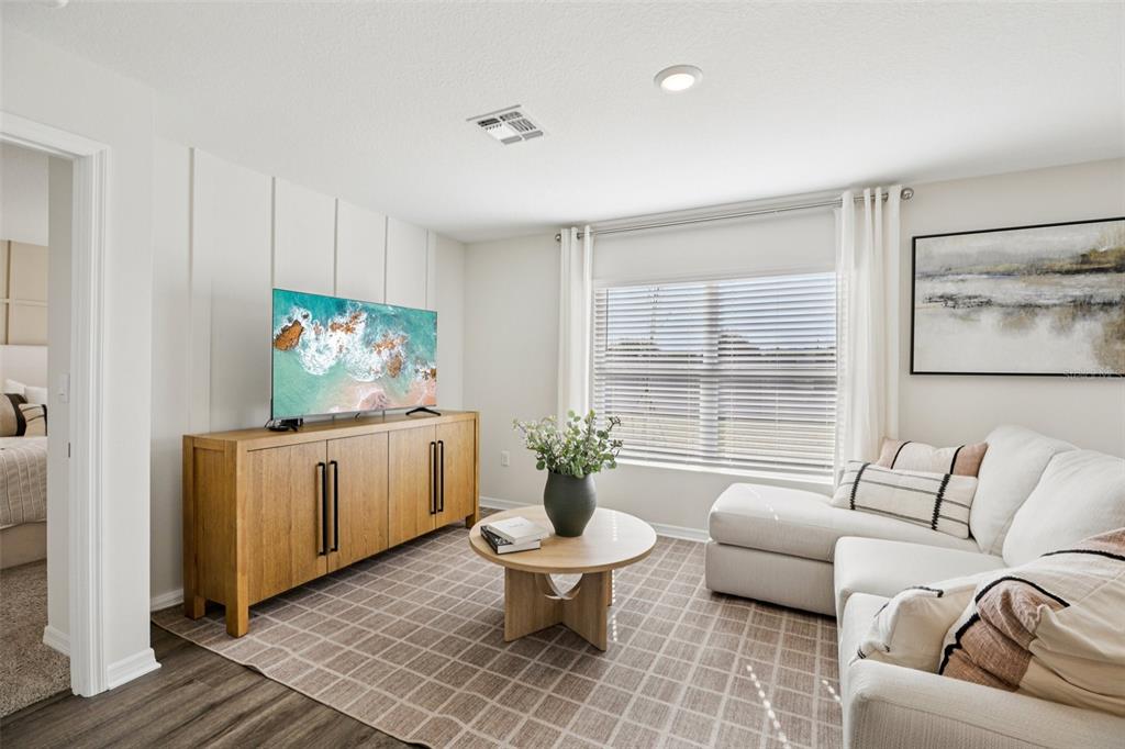 A living room features a light wood media console, a sectional sofa, and a round table — 765 GREENWAY BOULEVARD, LAKE WALES, FL