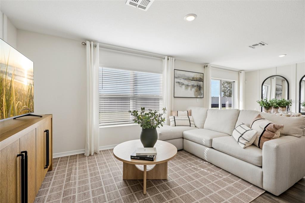 A living room features a light-colored sectional sofa, a round wooden coffee table, and a television — 765 GREENWAY BOULEVARD, LAKE WALES, FL