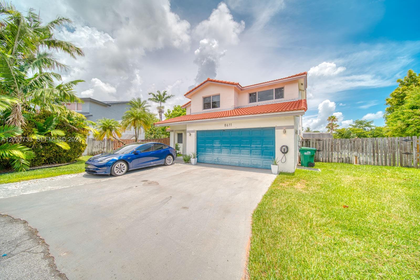 A two-story house with a blue garage door, a blue car, and a tiled roof — 8611 SW 207th Ter, Cutler Bay FL 33189, CUTLER BAY, FL